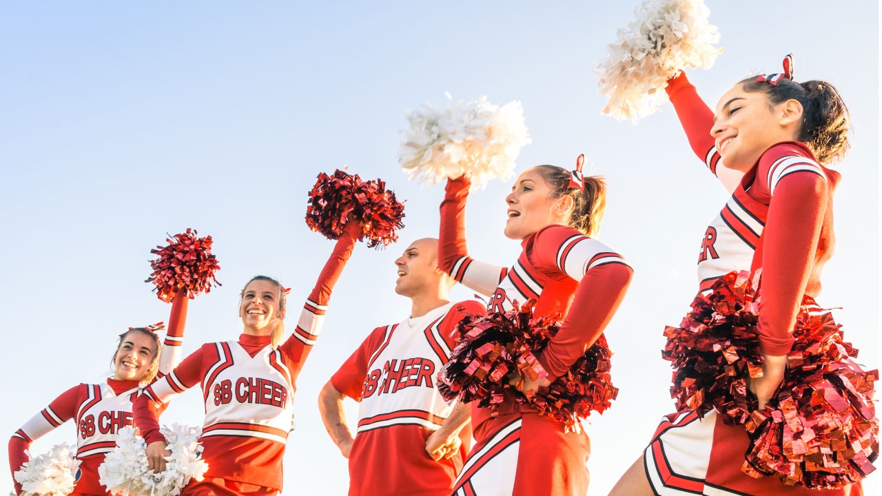 group of college cheerleaders waving pompoms; image used for HSBC International Services study abroad article, What it's like to study in the US