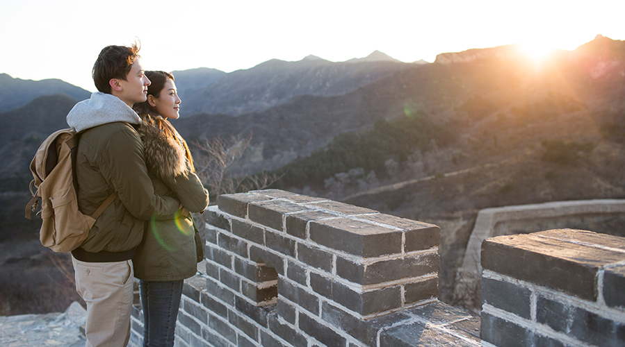 couple looking at view from Great Wall of China as sun sets; HSBC International Services for Chinese Executives, Coming to China